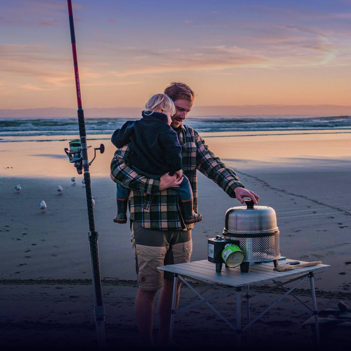 Family cooking on a Cobb grill at the beach